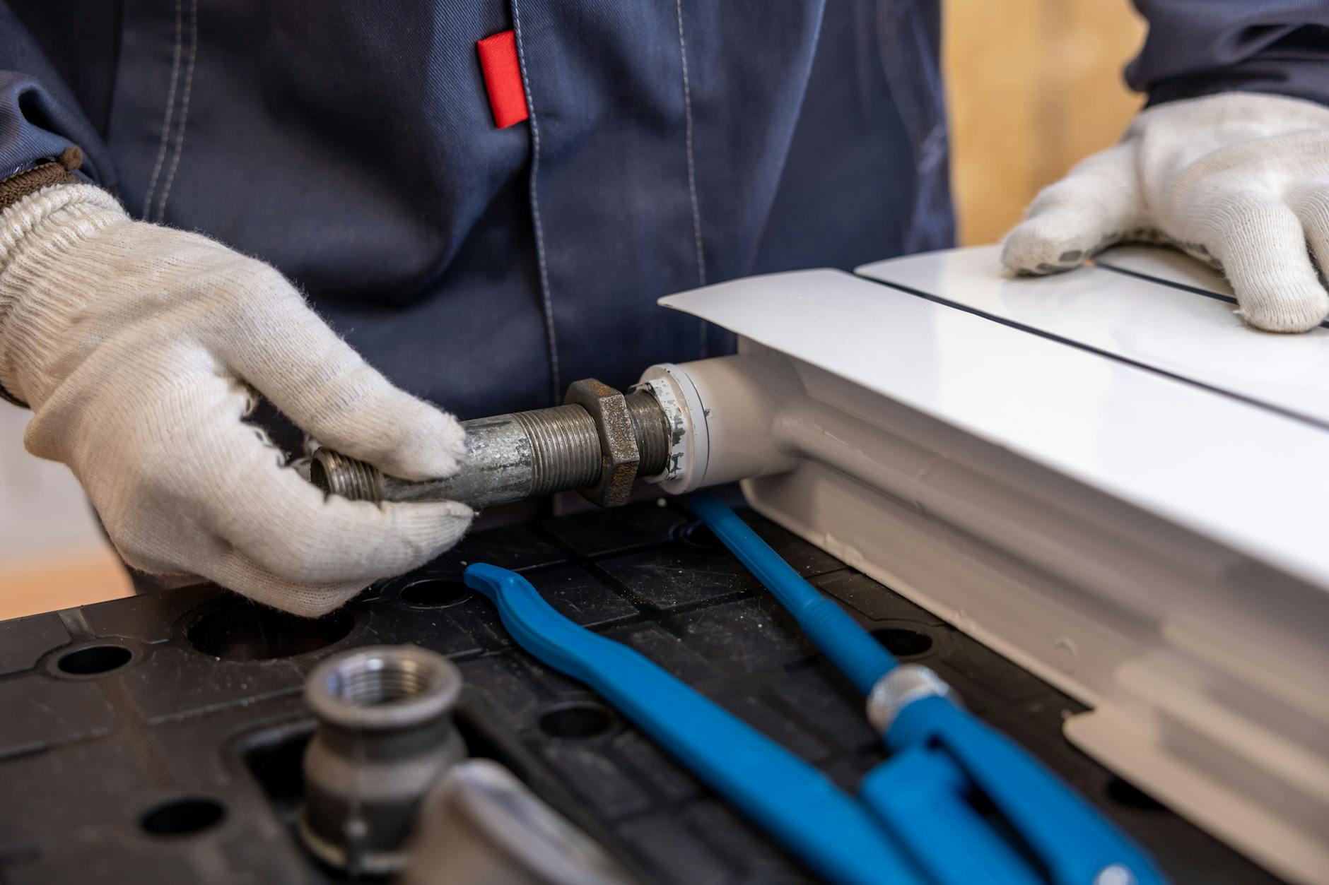 Master plumber inspecting under-sink plumbing — Smedley Plumbing Kansas City